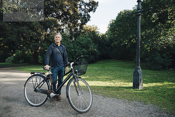 Porträt eines älteren Mannes mit Fahrrad im Park