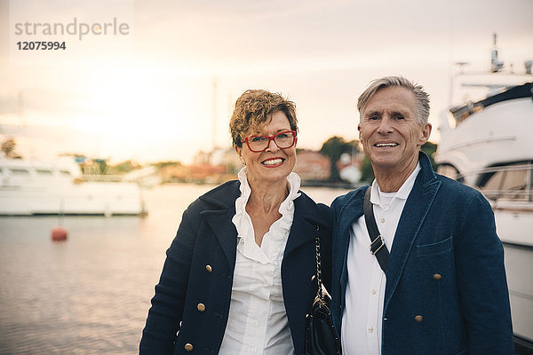 Porträt eines selbstbewussten Seniorenpaares mit einem Lächeln im Hafen