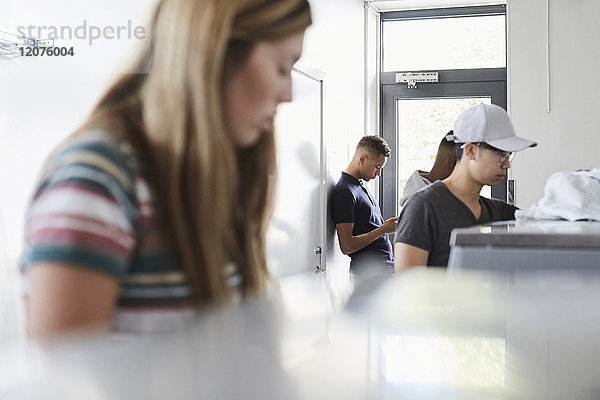 Telefonierender Mann während der Arbeit im Waschsalon