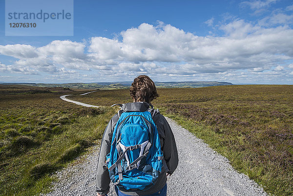 Irland  Grafschaft Cavan  Cuilcagh Mountain Park  Frau wandert entlang der Straße