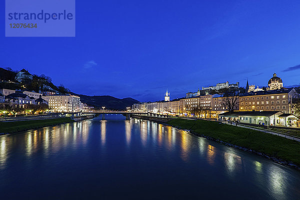 Österreich  Salzburg  Beleuchtete Stadthäuser am Flussufer