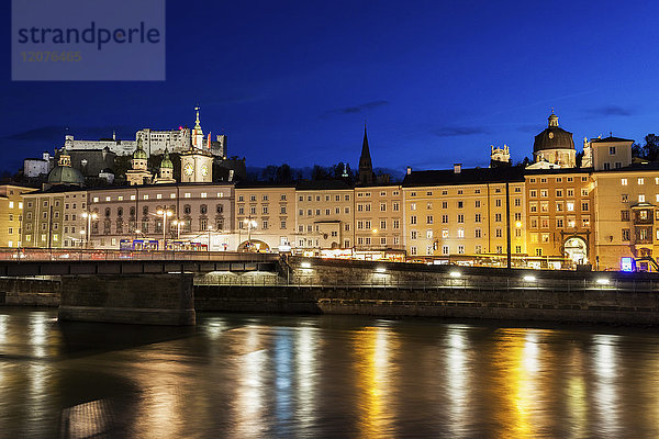 Österreich  Salzburg  Flussufer mit Gebäuden bei Nacht