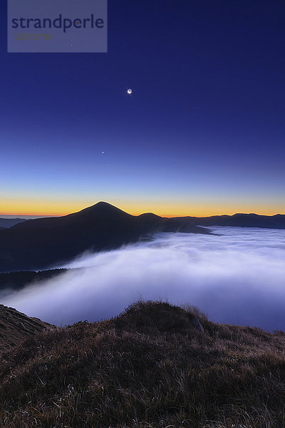 Ukraine  Gebiet Sakarpattia  Bezirk Rachiw  Karpaten  Chornohora  Berglandschaft mit Nebel in der Abenddämmerung