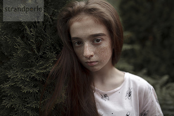 Porträt eines ernsten kaukasischen Mädchens mit Sommersprossen