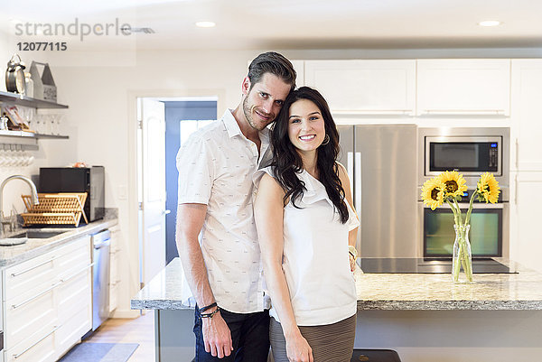 Porträt eines lächelnden kaukasischen Paares  das in der Küche steht