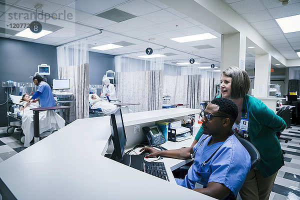 Arzt und Krankenschwester benutzen Computer im Krankenhaus