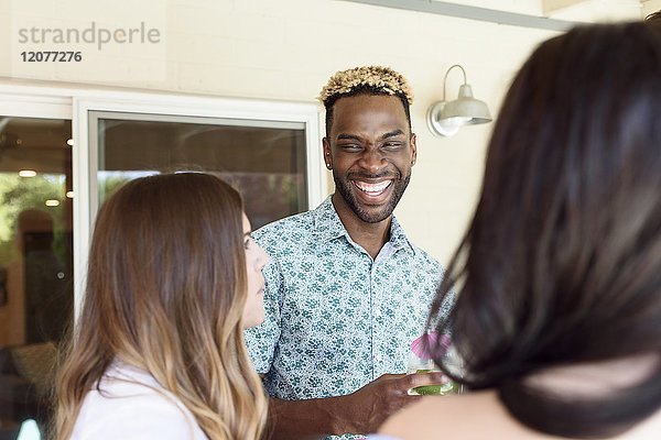 Freunde mit kalten Getränken lachen im Freien