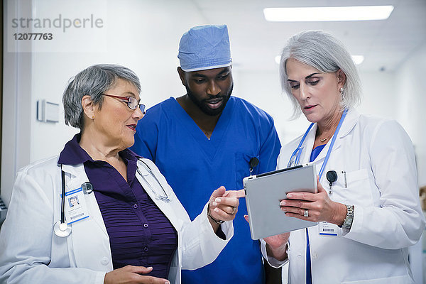 Ärzte und Krankenschwester diskutieren über das digitale Tablet