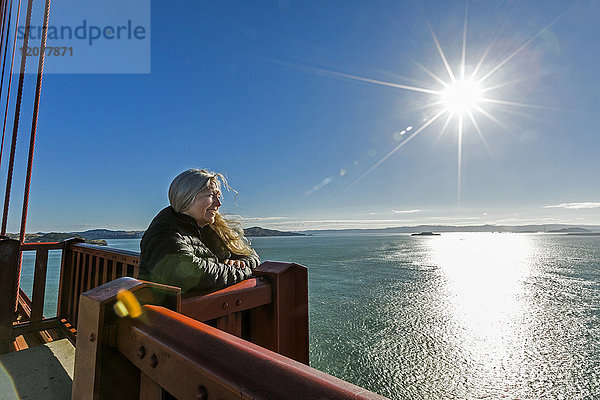 Kaukasische Frau bewundert die Aussicht auf einer Brücke