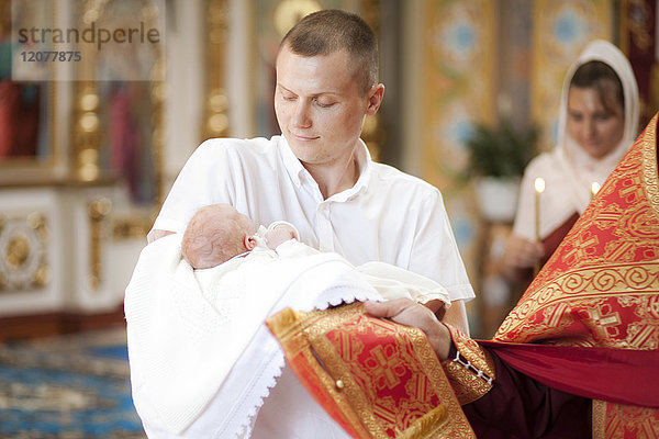 Vater hält seinen kleinen Sohn in der Kirche