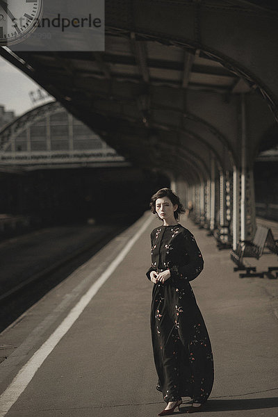 Kaukasische Frau wartet am Bahnhof