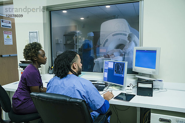 Krankenschwestern benutzen Computer in der Nähe des Scanners