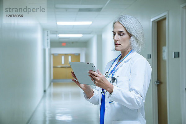 Kaukasischer Arzt verwendet digitales Tablet im Krankenhaus