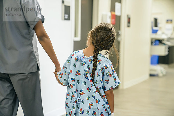Krankenschwester hält Hände mit Mädchen im Krankenhaus