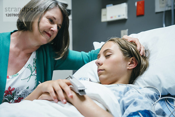 Kaukasische Mutter tröstet Tochter im Krankenhaus