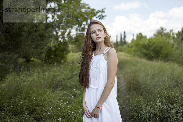 Nachdenkliches kaukasisches Mädchen auf einem Feld