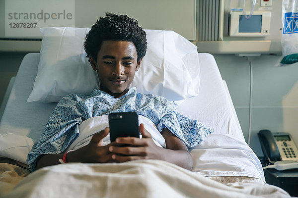 Schwarze Bretter  die im Krankenhausbett mit dem Handy telefonieren