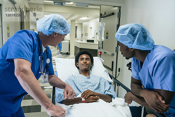 Krankenschwestern sprechen mit einem Jungen auf einer Krankenhausbahre