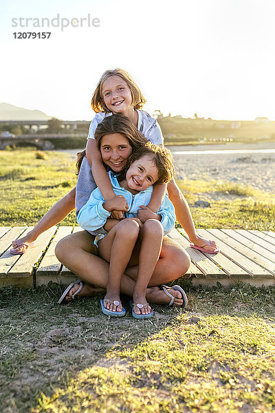 Gruppenbild von drei glücklichen Mädchen an der Strandpromenade