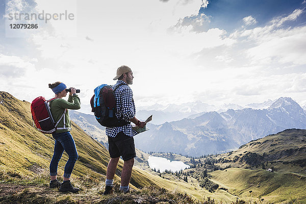 Deutschland  Bayern  Oberstdorf  zwei Wanderer mit Karte und Fernglas in alpiner Landschaft