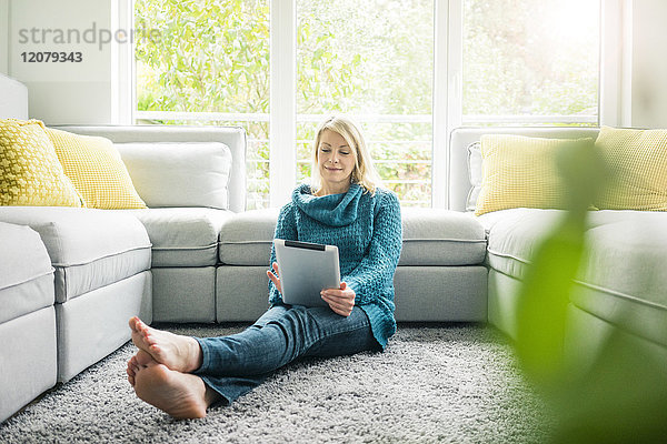 Frau mit Tablette im Wohnzimmer