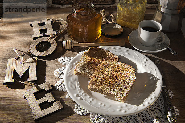 Frühstückstisch mit Toast  Orangenmarmelade  Honig und Espresso