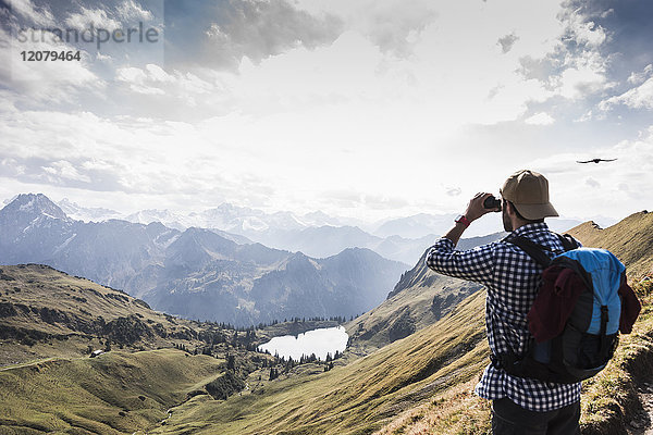 Deutschland  Bayern  Oberstdorf  Wanderer mit Fernglas in alpiner Umgebung