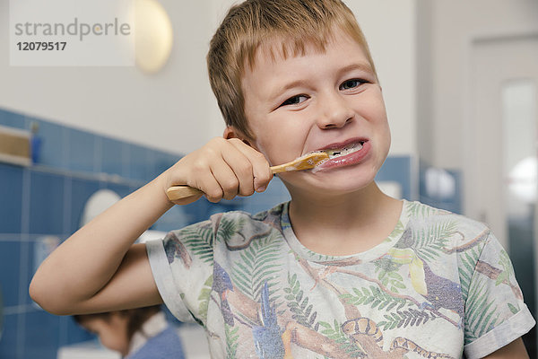 Porträt eines Jungen beim Zähneputzen im Bad eines Kindergartens