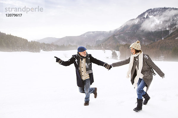 Seniorenpaar mit Spaß in verschneiter Landschaft