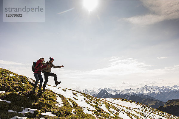 Deutschland  Bayern  Oberstdorf  zwei Wanderer  die auf der Alm springen
