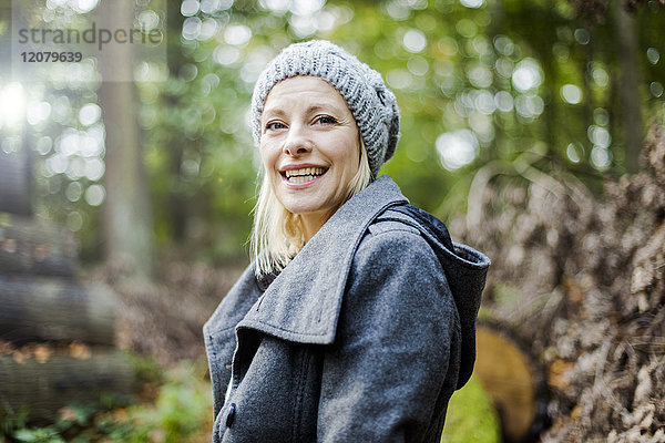Porträt einer glücklichen Frau im Wald im Herbst