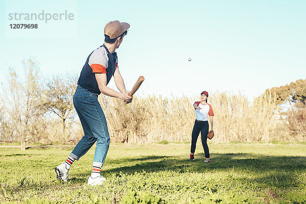 Junges Paar spielt Baseball im Park