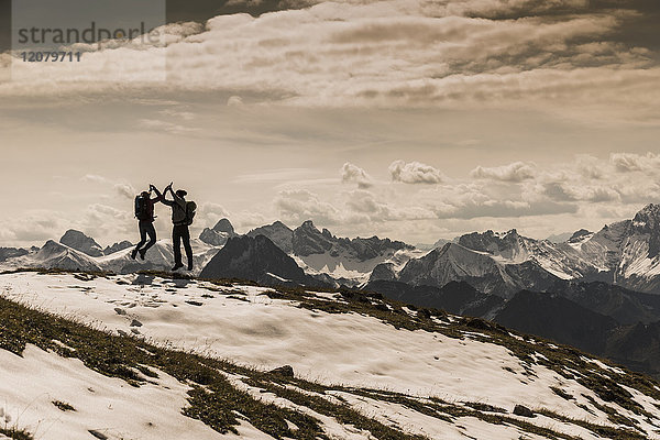 Deutschland  Bayern  Oberstdorf  zwei Wanderer beim Springen in alpiner Landschaft