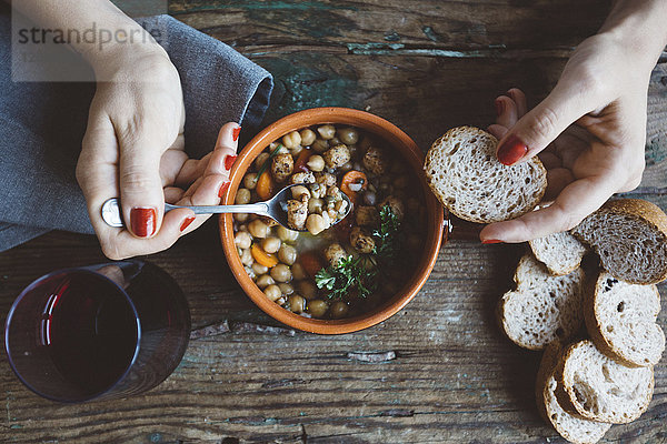 Frau isst mediterrane Suppe mit Brot  Nahaufnahme