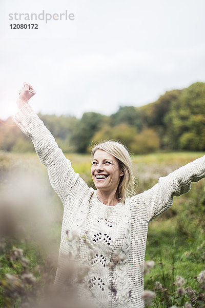 Porträt einer glücklichen blonden Frau im Freien