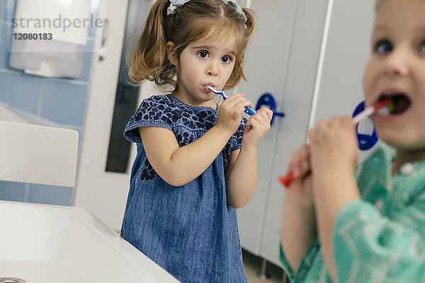 Kleine Mädchen beim Zähneputzen im Bad eines Kindergartens