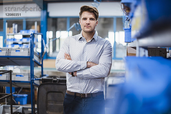 Porträt eines jungen Managers in der Werkstatt  Arme gekreuzt