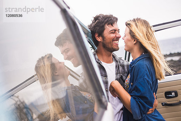 Spanien  Teneriffa  junges verliebtes Paar im Urlaub mit einem Lieferwagen am Meer