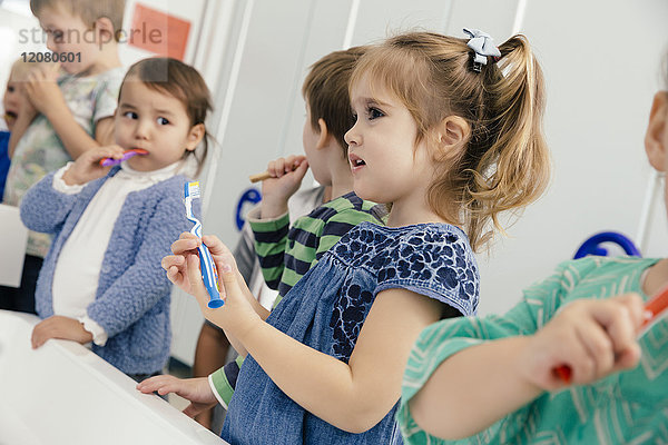 Kinder beim Zähneputzen im Bad eines Kindergartens