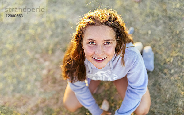 Porträt eines lächelnden Mädchens bei Dämmerung mit Blick nach oben