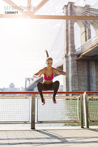 Athletinnen-Training in Manhattan bei Brooklyn Bridge  Springen in der Luft