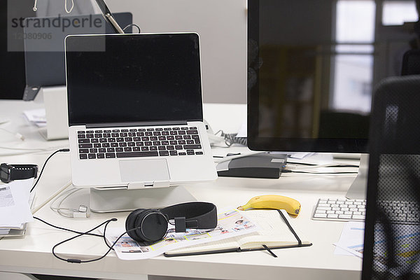 Laptop mit Kopfhörer auf dem Schreibtisch