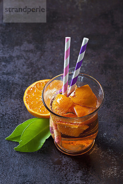Obstschorle von Mandarinen im Glas mit Trinkhalmen
