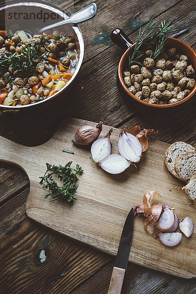 Mediterrane Suppe im Kupferkessel  Schüssel mit Croutons und Zutaten auf Holzbrettchen