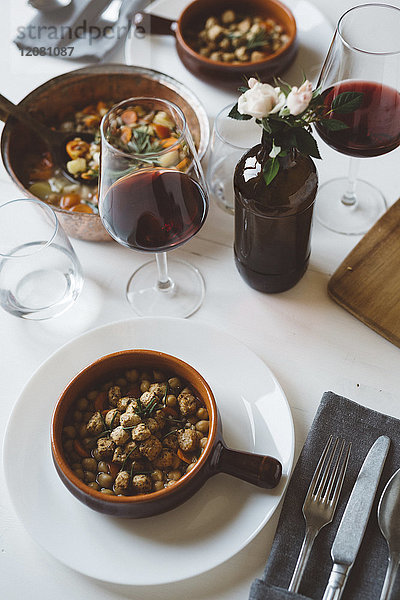 Gedeckter Tisch mit mediterraner Suppe und Rotwein