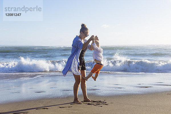 Indonesien  Bali  Mutter und Sohn spielen am Strand