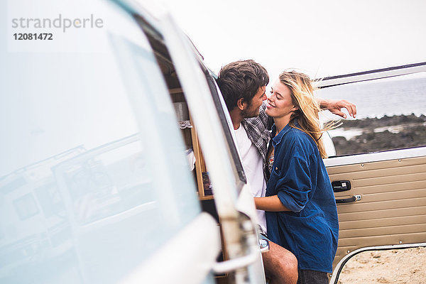 Spanien  Teneriffa  junges verliebtes Paar im Urlaub mit einem Lieferwagen am Meer