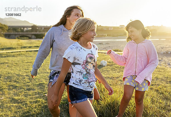 Vier Mädchen spielen im Freien bei Sonnenuntergang Mädchen auf der Strandpromenade