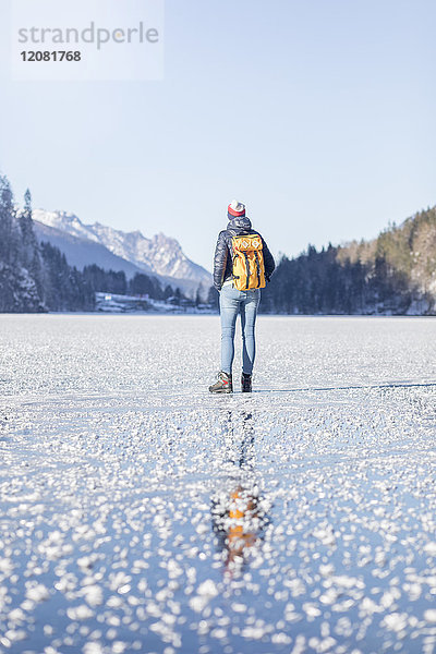 Deutschland  Berchtesgadener Land  Rückansicht der Frau mit Rucksack am gefrorenen Königssee