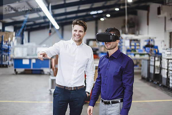 Zwei Mitarbeiter mit einer Besprechung  einer mit VR-Brille